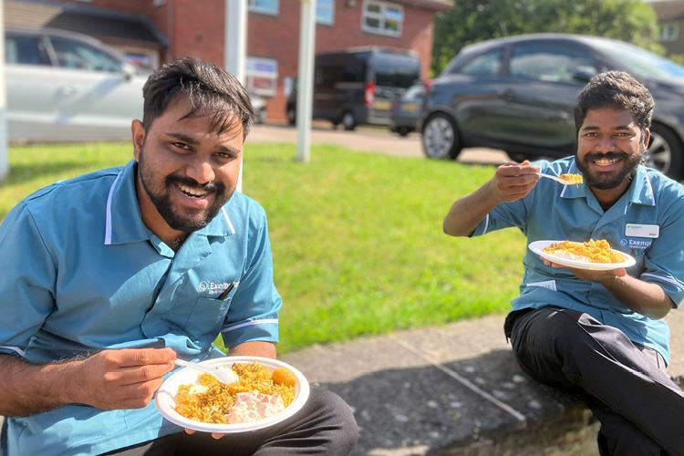 Two male colleagues eating outside 