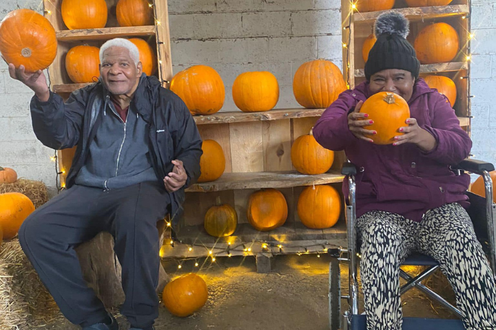 Two service users in wheelchairs at a pumpkin farm