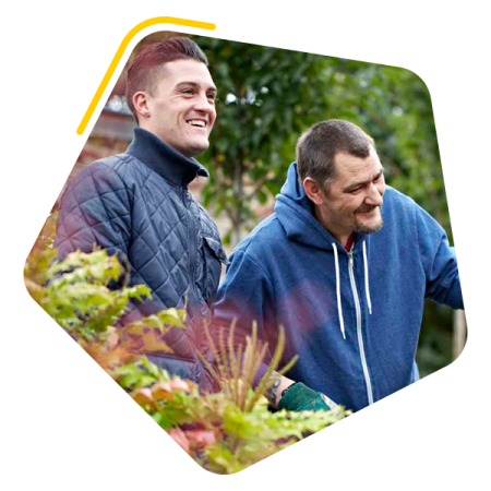 Male service user and colleague gardening