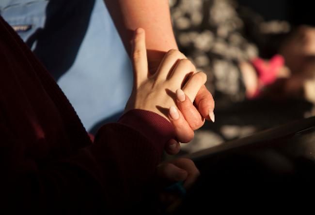 Service user and carer holding hands